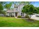 Charming two-story home featuring gray siding, a well-manicured lawn, mature trees, and a delightful, vibrant purple front door at 3908 Brittany Ct, Indian Trail, NC 28079
