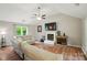 Bright living room with vaulted ceiling featuring a fireplace, hardwood floors, and a large sofa perfect for entertaining at 3908 Brittany Ct, Indian Trail, NC 28079