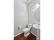 A well-lit half bath features a pedestal sink, dark wood floors, and light gray walls at 4011 Black Walnut Way, Indian Land, SC 29707
