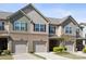 A townhome's exterior features brick accents, siding, and convenient attached garages at 4011 Black Walnut Way, Indian Land, SC 29707