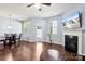 Spacious living room with a view of the dining area, fireplace, ceiling fan, flat screen, and wood floors at 4011 Black Walnut Way, Indian Land, SC 29707