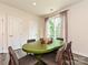 Dining area featuring green table, patio doors, and neutral decor at 417 Tristram Ln, Charlotte, NC 28205
