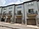 Row of three-story townhomes with balconies and garage doors at 417 Tristram Ln, Charlotte, NC 28205