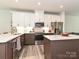 Modern kitchen with white cabinetry, stainless steel appliances, island with quartz countertops, and hardwood floors at 417 Tristram Ln, Charlotte, NC 28205