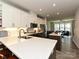 Open kitchen with white cabinets, island, stainless appliances, flowing into living space at 417 Tristram Ln, Charlotte, NC 28205