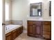 Bright bathroom features a soaking tub with wood-paneled base, stylish mirror, and tile flooring at 4193 He Propst Rd, Maiden, NC 28650