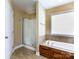 This bathroom offers a large soaking tub, glass enclosed shower, and neutral tile flooring at 4193 He Propst Rd, Maiden, NC 28650