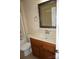 Bathroom showcasing a wooden vanity with a white countertop, a decorative mirror, and a toilet at 4193 He Propst Rd, Maiden, NC 28650