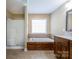 Bathroom showcasing a soaking tub, glass-enclosed shower, vanity, and neutral wall color at 4193 He Propst Rd, Maiden, NC 28650