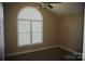 Cozy bedroom with carpet flooring, neutral paint, and a bright arched window at 4193 He Propst Rd, Maiden, NC 28650