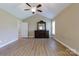 Spacious primary bedroom featuring wood floors, ceiling fan, large mirror, and neutral walls at 4193 He Propst Rd, Maiden, NC 28650