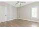 Neutral bedroom featuring light hardwood floors, single window with shutter and a door for closet or bathroom access at 5538 Camelot Dr, Charlotte, NC 28270