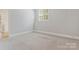 This bedroom has neutral walls, trim, carpet and a window with horizontal blinds at 5538 Camelot Dr, Charlotte, NC 28270