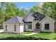 Beautifully landscaped modern home with white painted brick, a black roof, and black trim at 5538 Camelot Dr, Charlotte, NC 28270