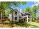 Exterior view of the back of the house, with its white brick, chimney, stairs and screened-in porch at 5538 Camelot Dr, Charlotte, NC 28270