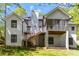 Back exterior view of home featuring white brick, white chimney, wooden stairs and screened-in porch at 5538 Camelot Dr, Charlotte, NC 28270