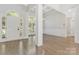 Open foyer with hardwood flooring, white trim, large windows and arched entryway at 5538 Camelot Dr, Charlotte, NC 28270