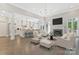 Open-concept living room with fireplace, hardwood floors, open access to the kitchen, and modern furniture at 5538 Camelot Dr, Charlotte, NC 28270
