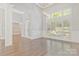 Living room with hardwood flooring, large windows with shutters, and an arched entryway at 5538 Camelot Dr, Charlotte, NC 28270