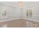 Office with hardwood flooring, two windows with shutters, wainscoting, chandelier, and a desk at 5538 Camelot Dr, Charlotte, NC 28270