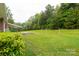 Spacious backyard featuring lush grass, mature trees, and cozy covered patio area at 5840 Shirley Rd, Fort Lawn, SC 29714