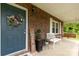 Cozy front porch featuring a bench, brick exterior, and a decorative wreath on the front door at 5840 Shirley Rd, Fort Lawn, SC 29714