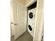 Laundry room closet with a stacked washer and dryer on a gray hexagon tiled floor at 627 N Alexander St, Charlotte, NC 28202