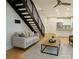 Bright living room featuring hardwood floors, comfortable seating, and open staircase to the second floor at 627 N Alexander St, Charlotte, NC 28202
