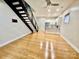 Bright living room features hardwood floors, stairs, a ceiling fan and open access to the modern kitchen at 627 N Alexander St, Charlotte, NC 28202