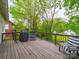 Spacious back deck with a grill, lounge chair, and wooded views of backyard at 705 N Fulton St, Salisbury, NC 28144