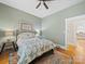 Bedroom featuring green walls, hardwood floors, a ceiling fan, and two windows at 705 N Fulton St, Salisbury, NC 28144
