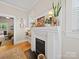 Classic white fireplace with decorative plants, wall lighting, and a peek into the living room at 705 N Fulton St, Salisbury, NC 28144