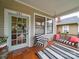 Inviting front porch with porch swing, striped chair and rug, and painted front door with decorative wreath at 705 N Fulton St, Salisbury, NC 28144