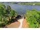 Stunning aerial view of lakefront home surrounded by mature trees with an inviting driveway at 8058 Edgewater Dr, Norwood, NC 28128