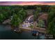 Stunning aerial view of lakefront home with pool, boat docks, and lush surroundings at 8058 Edgewater Dr, Norwood, NC 28128