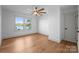 Bedroom features hardwood floors, natural light from oversized windows, and a ceiling fan at 8058 Edgewater Dr, Norwood, NC 28128