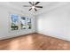 Cozy bedroom with hardwood floors, natural light from oversized windows, and a ceiling fan at 8058 Edgewater Dr, Norwood, NC 28128