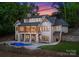 Stunning two-story home boasts a spacious deck, stone accents, lush landscaping, and a private pool for luxurious outdoor living at 8058 Edgewater Dr, Norwood, NC 28128