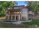 Luxury home with covered porch and pool, set against a wooded backdrop at 8058 Edgewater Dr, Norwood, NC 28128