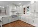 Modern kitchen features white cabinets, stainless steel appliances, and a view of the staircase at 8058 Edgewater Dr, Norwood, NC 28128