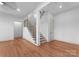 Open room with hardwood floors, a staircase, and natural lighting at 8058 Edgewater Dr, Norwood, NC 28128