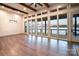 Lake views from this open living room with hardwood floors, wood beams, large windows, and access to a deck at 8058 Edgewater Dr, Norwood, NC 28128