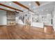 Spacious living area features a stone fireplace, wood beams, hardwood floors, an open staircase, and access to a modern kitchen at 8058 Edgewater Dr, Norwood, NC 28128