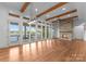 Spacious living room with stone fireplace, hardwood floors, and expansive windows with lake view at 8058 Edgewater Dr, Norwood, NC 28128