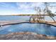 Gorgeous lake view from the pool deck, featuring a private dock and peaceful surroundings for relaxing waterfront living at 8058 Edgewater Dr, Norwood, NC 28128