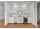 This wet bar includes a wine fridge, KitchenAid dishwasher, marble countertops, and a subway tile backsplash at 8058 Edgewater Dr, Norwood, NC 28128