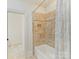 Tiled shower and bathtub combination with a shower curtain in a bathroom with tile flooring at 825 Hudson Pl, Davidson, NC 28036