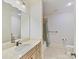 Neutral bathroom featuring a vanity with storage, a mirror, and a bathtub with shower at 825 Hudson Pl, Davidson, NC 28036
