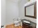 A well-lit half-bath features hardwood floors, a dark vanity, and a decorative mirror at 825 Hudson Pl, Davidson, NC 28036