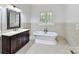 Bright bathroom with a stand alone tub, ornate vanity, and natural light at 825 Hudson Pl, Davidson, NC 28036
